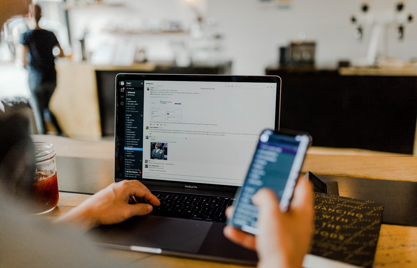 Profissional utilizando computador e celular em ambiente digital