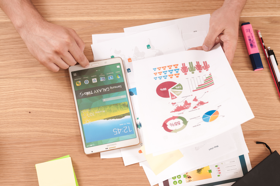 Documentos e dispositivo digital sobre mesa de trabalho